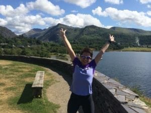 Photo to welcome Lucy Dine shows her celebrating a great run in beautiful scenery